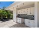 Outdoor kitchen with white cabinets and stone countertops at 6817 Riverview Blvd, Bradenton, FL 34209