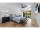 Main bedroom with a king-size bed, ceiling fan, and access to patio at 6817 Riverview Blvd, Bradenton, FL 34209