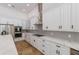 Modern kitchen with white cabinets, quartz countertops, and stainless steel appliances at 6817 Riverview Blvd, Bradenton, FL 34209