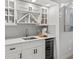 White wet bar with quartz countertops, wine cooler and glass cabinets at 6817 Riverview Blvd, Bradenton, FL 34209
