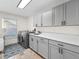 Bright laundry room featuring gray cabinets and quartz countertops at 6817 Riverview Blvd, Bradenton, FL 34209