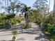 Gated community entrance with lush landscaping and paved road at 7317 Crape Myrtle Way, Sarasota, FL 34241
