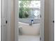 Bathroom featuring a soaking tub, open doorway with hanging plants at 7317 Crape Myrtle Way, Sarasota, FL 34241