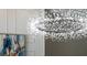 Modern chandelier in a room with white walls and an abstract painting in a neutral palette at 7317 Crape Myrtle Way, Sarasota, FL 34241