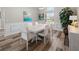 Inviting dining room with a long white table, modern art, and ample natural light at 7317 Crape Myrtle Way, Sarasota, FL 34241