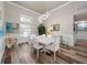 Elegant dining room with a white table set, modern lighting, and wood-look tile floors at 7317 Crape Myrtle Way, Sarasota, FL 34241