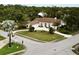 Beautiful home with a circular driveway, lush landscaping, and a well-maintained lawn, offering a welcoming curb appeal at 7317 Crape Myrtle Way, Sarasota, FL 34241