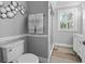 Grey bathroom with a toilet and shower at 7317 Crape Myrtle Way, Sarasota, FL 34241
