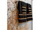Close-up of black and gold towels hanging in a modern bathroom at 7317 Crape Myrtle Way, Sarasota, FL 34241