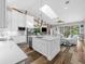 Open concept kitchen with a large center island, white cabinets, stainless steel appliances, and bright, airy living space at 7317 Crape Myrtle Way, Sarasota, FL 34241