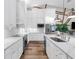 Bright kitchen featuring white cabinets, stainless steel appliances, wood-style tile floors and a center island with sink at 7317 Crape Myrtle Way, Sarasota, FL 34241