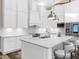 Elegant kitchen featuring white cabinets, stainless steel appliances, an island with seating, and pendant lighting at 7317 Crape Myrtle Way, Sarasota, FL 34241