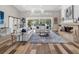 Bright living room with hardwood floors, a fireplace, and large sliding glass doors to the outdoor pool area at 7317 Crape Myrtle Way, Sarasota, FL 34241