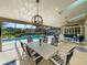 Covered patio with dining and lounging areas overlooks pool and landscaped backyard at 7317 Crape Myrtle Way, Sarasota, FL 34241
