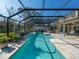 Inviting screened-in pool area featuring a spacious deck, lush landscaping, and serene water features at 7317 Crape Myrtle Way, Sarasota, FL 34241