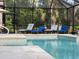 Relaxing pool area with lounge chairs under a covered patio at 7317 Crape Myrtle Way, Sarasota, FL 34241