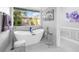Spacious bathroom with a freestanding tub and a view of the courtyard at 7317 Crape Myrtle Way, Sarasota, FL 34241