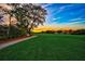 Scenic golf course view at sunset with a clubhouse in the distance at 854 Macewen Dr, Osprey, FL 34229