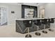 Modern wet bar with black cabinets and lion-head barstools at 854 Macewen Dr, Osprey, FL 34229