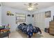 A colorful bedroom with a ceiling fan, a large window, and a closet with folding doors at 1017 Waterside St, Port Charlotte, FL 33952