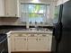 Bright kitchen with white cabinets, black appliances, and tile floor at 1105 58Th S St, Gulfport, FL 33707