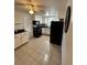 Bright kitchen with white cabinets, black appliances, and tile floor at 1105 58Th S St, Gulfport, FL 33707