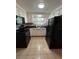 Bright kitchen with white cabinets, black appliances, and tile floor at 1105 58Th S St, Gulfport, FL 33707