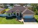 Aerial view of a single-story home featuring a well-manicured lawn, brick driveway, and attached garage at 1900 Colleen St, Sarasota, FL 34231