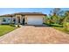 Multi-colored paver driveway leading to a tan one-story house with attached garage at 1900 Colleen St, Sarasota, FL 34231