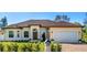 Inviting single-story home featuring a manicured lawn, arched entryway, brick driveway, and attached garage at 1900 Colleen St, Sarasota, FL 34231