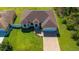 An aerial view shows a house with a paved driveway and lush lawn at 1900 Colleen St, Sarasota, FL 34231