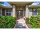 Inviting front entry with a covered porch and lush landscaping at 29205 Saddlebag Trl, Myakka City, FL 34251