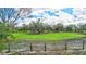 Open pasture land with mature trees and a wooden fence at 29205 Saddlebag Trl, Myakka City, FL 34251