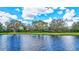 Ranch home with pond view, lush landscaping, and a long driveway at 29205 Saddlebag Trl, Myakka City, FL 34251