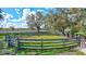 Round pen with wooden fence in a grassy area at 29205 Saddlebag Trl, Myakka City, FL 34251