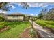 Single story home with landscaped yard, walkway, and a lamp post at 29205 Saddlebag Trl, Myakka City, FL 34251