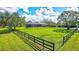 Large backyard with a home, wooden fence, and lush grass at 29205 Saddlebag Trl, Myakka City, FL 34251