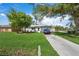 Ranch style home with a tree in front and a car parked in the driveway at 4457 Brooksdale Dr, Sarasota, FL 34232
