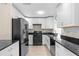 Modern kitchen with white cabinets, black appliances, and granite countertops at 4457 Brooksdale Dr, Sarasota, FL 34232
