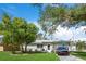 Ranch style home with a tree in front and a car parked in the driveway at 4457 Brooksdale Dr, Sarasota, FL 34232