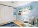 Bedroom with built-in white wardrobe, armchair, and light blue walls at 4873 Village Gardens Dr # 191, Sarasota, FL 34234