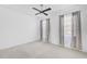 Bright bedroom featuring two windows with modern curtains and a ceiling fan at 805 Molly Cir, Sarasota, FL 34232