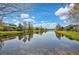 Scenic view of the pond with beautiful sky, mature trees and lush green lawns surrounding the water at 805 Molly Cir, Sarasota, FL 34232