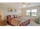 King-size bed, ceiling fan, and large window in this tranquil bedroom at 1100 Capri Isles Blvd # 523, Venice, FL 34292