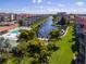 Aerial view of community pool, lush grounds, and canal at 1215 S Portofino Dr # 404, Sarasota, FL 34242