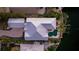 Aerial view of home showcasing the backyard pool, metal roof, and surrounding lush landscaping at 1243 Starboard Ln, Sarasota, FL 34242