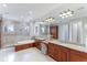 Large bathroom with double vanity, stone floors, a soaking tub, and a glass walk-in shower at 1243 Starboard Ln, Sarasota, FL 34242