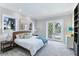 Bright bedroom with a king bed, neutral color palette, balcony access, and two large windows at 1243 Starboard Ln, Sarasota, FL 34242