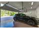 Spacious garage featuring an open overhead door, shiny floor and a sleek black SUV at 1243 Starboard Ln, Sarasota, FL 34242