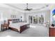 Large main bedroom with tray ceiling, ceiling fan, access to the balcony, and ample light at 1243 Starboard Ln, Sarasota, FL 34242